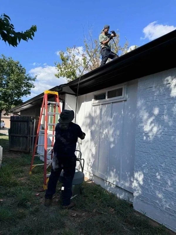 A man on the roof of a house