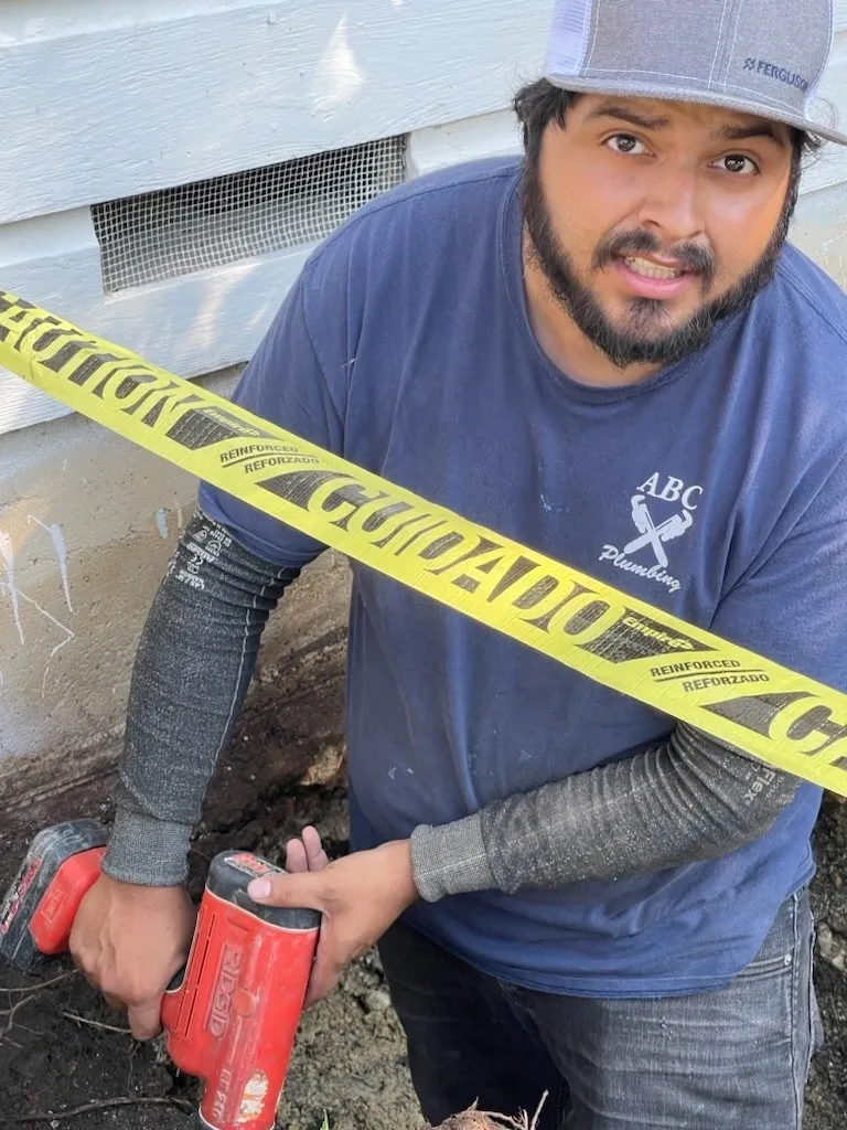 A man holding a hammer and tape measure.