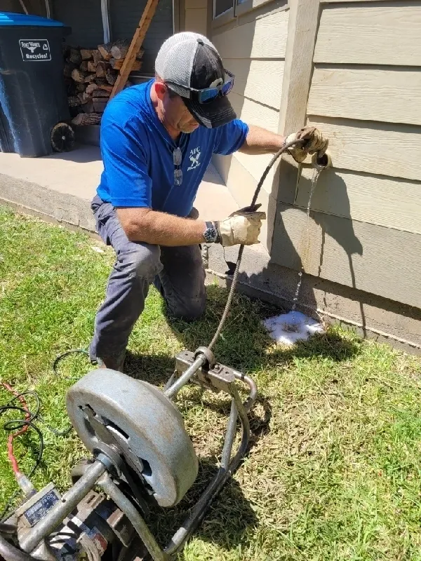 A man in blue shirt and mask painting the side of house.