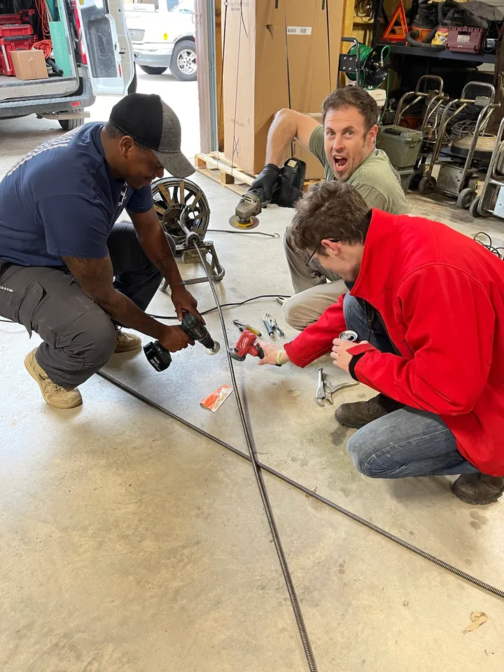 A group of men working on a project in the garage.