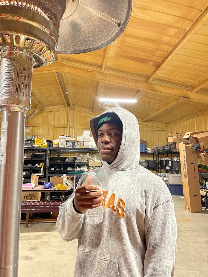 A man in a white hoodie holding something.