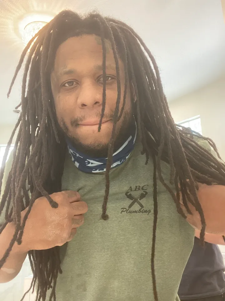 A man with long dreadlocks and a bandana around his neck.