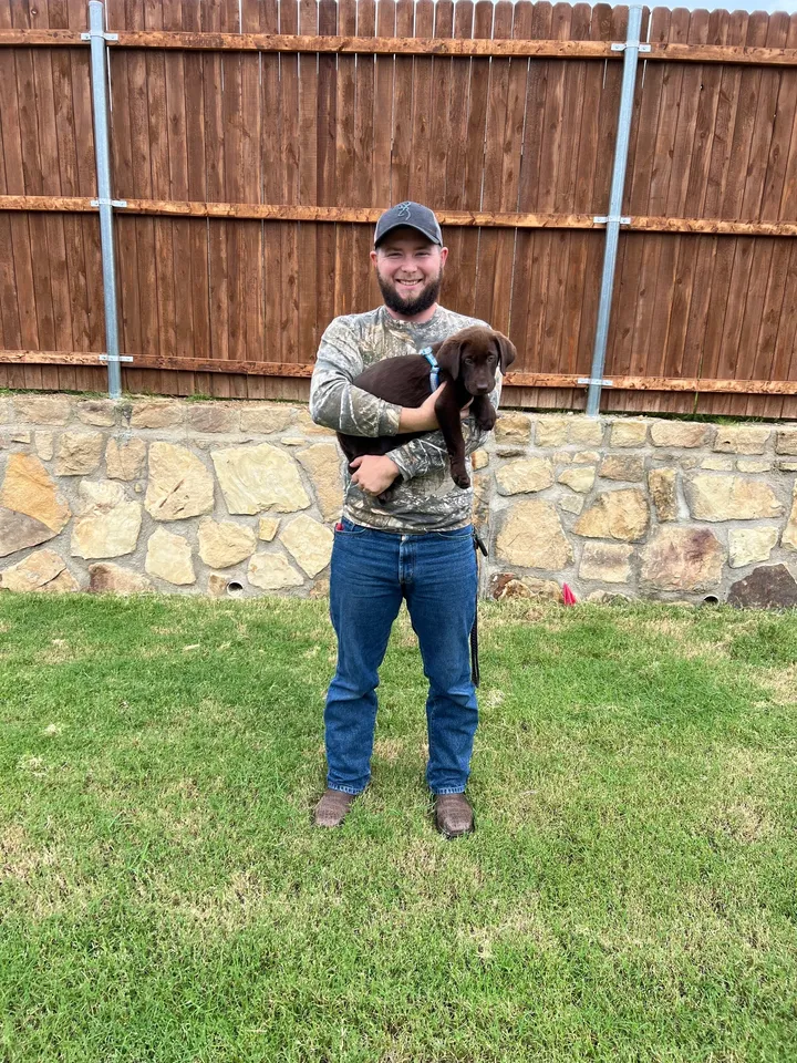 A man holding a dog in his arms.