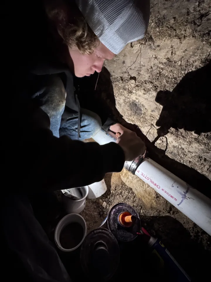 A person is lighting candles on the ground