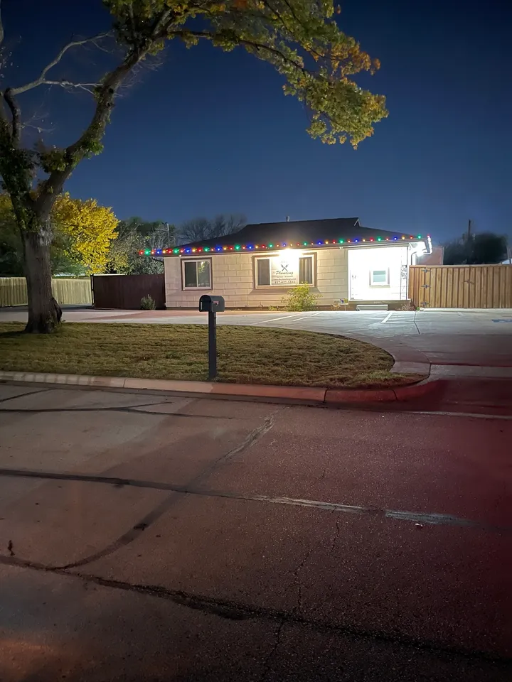 A street corner with a mailbox and a house in the background.